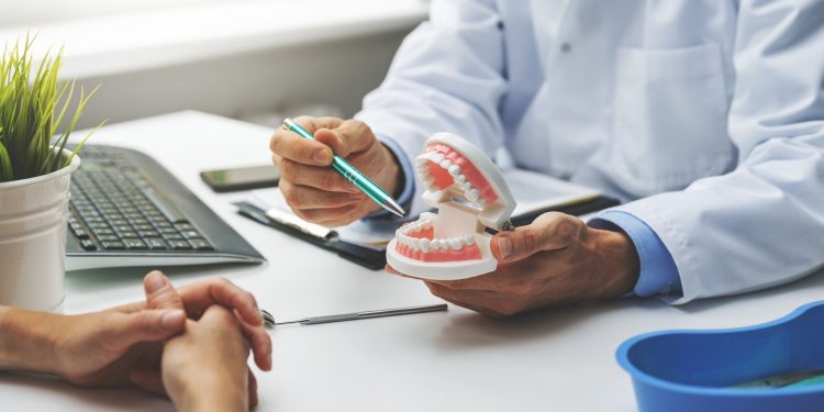 dentist and patient discussion about planned teeth treatment in dental clinic office