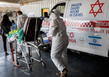 Magen David Adom workers wearing protective clothing outside the coronavirus unit at Shaare Zedek hospital in Jerusalem on September 14, 2020. Photo by Nati Shohat/Flash90 *** Local Caption *** קורונה
בית חולים
שערי צדק
וירוס
לבן
לבושים
מפנים
מד"א