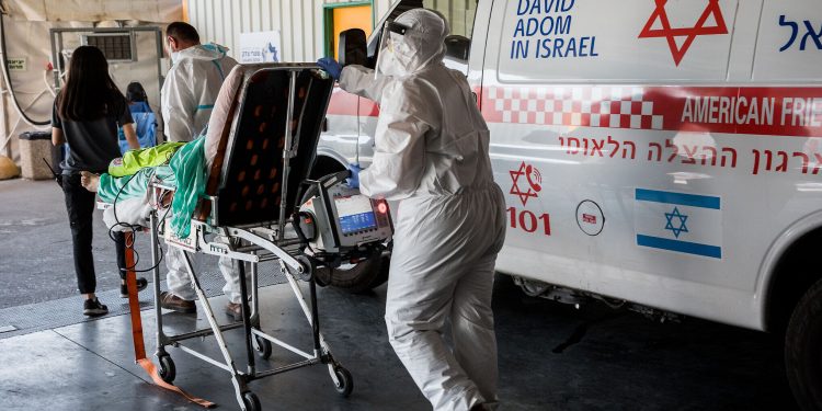 Magen David Adom workers wearing protective clothing outside the coronavirus unit at Shaare Zedek hospital in Jerusalem on September 14, 2020. Photo by Nati Shohat/Flash90 *** Local Caption *** קורונה
בית חולים
שערי צדק
וירוס
לבן
לבושים
מפנים
מד"א