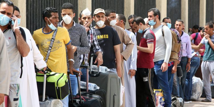 Egyptians queue up outside a school that was turned into a centre to receive residency violators wishing to avail an amnesty Kuwait announced for April, amid the coronavirus COVID-19 pandemic crisis, in Kuwait City on April 6, 2020. (Photo by YASSER AL-ZAYYAT / AFP)