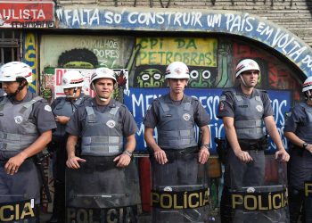 Police officers stand at attention as students protest against the country's latest round of transport fare hikes, in Sao Paulo, Brazil, on January 16, 2015. Amid a marked economic downturn and high inflation, bus fares went up in Sao Paulo, Brazil's largest city, from 3 to 3.50 reais, and in Rio, the former capital, from 3.0 to 3.40 reais. Rio's 13 percent hike is almost exactly double the current rate of inflation.  AFP PHOTO / NELSON ALMEIDA / AFP PHOTO / NELSON ALMEIDA